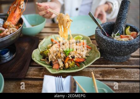 Donna che ha un pasto con Pad vedere uova saltate in padella In un ristorante tailandese Foto Stock