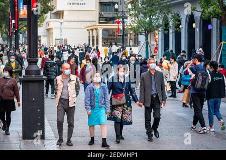 Wuhan Cina , 14 febbraio 2021 : persone che indossano la maschera chirurgica sulla 2021 settimane di vacanza cinese nuovo anno in Jianghan strada pedonale in Wuhan Hub Foto Stock