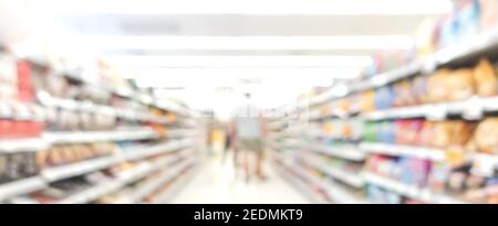 Immagine sfocata della corsia nel supermercato con i clienti - panoramica sfondo banner Foto Stock