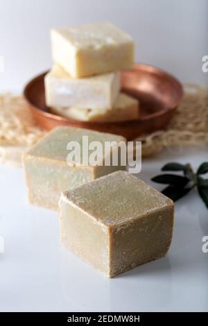 Sapone tagliato a mano a base di olio d'oliva su sfondo bianco. Foto Stock