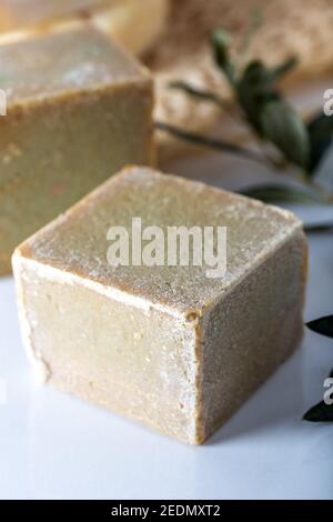 Sapone tagliato a mano a base di olio d'oliva su sfondo bianco. Foto Stock