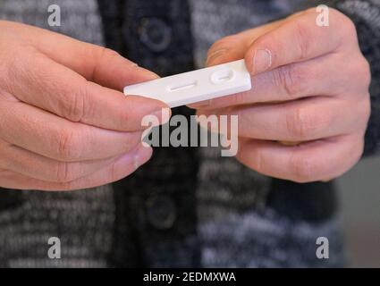 Potsdam, Germania. 15 Feb 2021. Thomas Hoß, direttore del centro di assistenza diurna, dimostra un rapido test Corona presso il centro di assistenza diurna "Abenteuerland" durante una visita del ministro federale della famiglia Giffey e del sindaco di Potsdam Schubert. I test di spit sono stati utilizzati dagli educatori di day care fin dall'inizio del mese per testarsi due volte alla settimana a casa prima del lavoro. Credit: Soeren Stache/dpa-Zentralbild/POOL/dpa/Alamy Live News Foto Stock