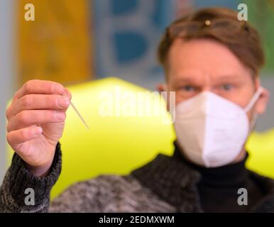 Potsdam, Germania. 15 Feb 2021. Thomas Hoß, direttore del centro di assistenza diurna, dimostra un rapido test Corona presso il centro di assistenza diurna "Abenteuerland" durante una visita del ministro federale della famiglia Giffey e del sindaco di Potsdam Schubert. I test di spit sono stati utilizzati dagli educatori di day care fin dall'inizio del mese per testarsi due volte alla settimana a casa prima del lavoro. Credit: Soeren Stache/dpa-Zentralbild/POOL/dpa/Alamy Live News Foto Stock