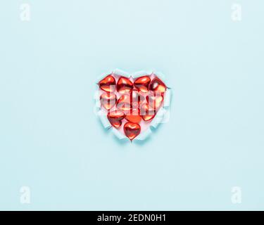 Cuore di carta strappato brillante su sfondo luminoso. Amore minimo o come concetto. Disposizione piatta. Foto Stock