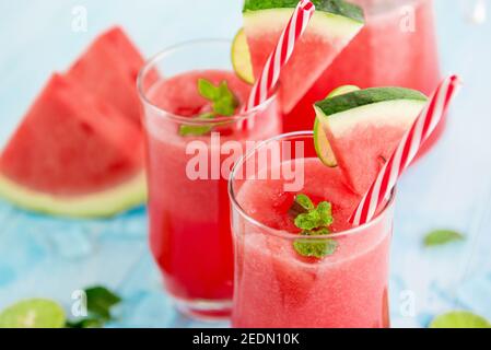 Bevande rinfrescanti colorate per l'estate, frullati freddi di succo di limonata di anguria nei bicchieri Foto Stock