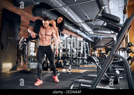 Allestitore forte che trasporta la fidanzata sulle spalle durante l'allenamento Foto Stock