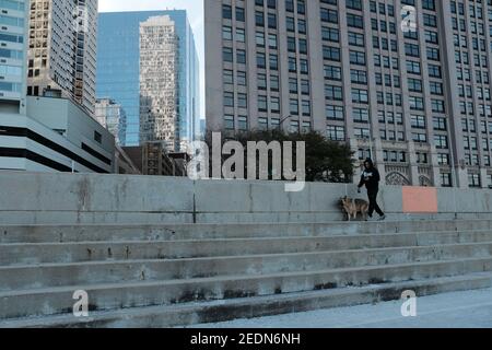 CHICAGO - 9 NOVEMBRE 2019: Un uomo che cammina il suo cane lungo il Lakefront Trail a Chicago, Illinois. Foto Stock