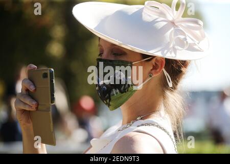 13.09.2020, Iffezheim, Baden-Wuerttemberg, Germania - Moda: Donna elegantemente vestita in un cappello indossa un protettore boccale fai da te e scatta foto con Foto Stock