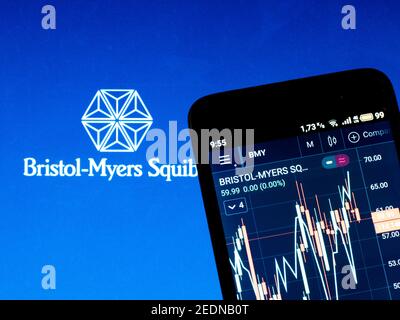 In questa illustrazione della foto le informazioni del mercato azionario di Bristol Myers Squibb viene visualizzato su uno smartphone mentre il logo di Bristol Myers Squibb viene visualizzato come sfondo Foto Stock