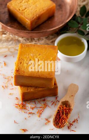 Sapone di zafferano fatto a mano con filetti di spezie di zafferano sul marmo Foto Stock