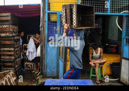 28.06.2014, Yangon, , Myanmar - UN lavoratore impila scatole vuote al mercato tradizionale del pesce di Baho San Pya, un mercato all'ingrosso nella capitale commerciale Foto Stock