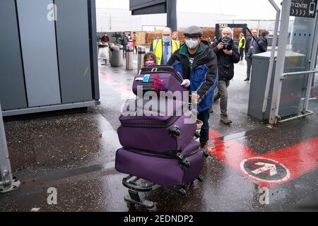 Edimburgo, Scozia, Regno Unito. 15 Feb 2021. Da oggi il governo scozzese richiede a tutti i passeggeri provenienti dall'estero che arrivano negli aeroporti scozzesi di entrare in una quarantena obbligatoria in un hotel. PIC; la prima famiglia che ha transitato in Scozia via Dublino per andare in quarantena arriva all'aeroporto di Edimburgo e sono scortati su un autobus che li porterà ad un hotel sorvegliato per la quarantena. Iain Masterton/Alamy Notizie dal vivo Foto Stock