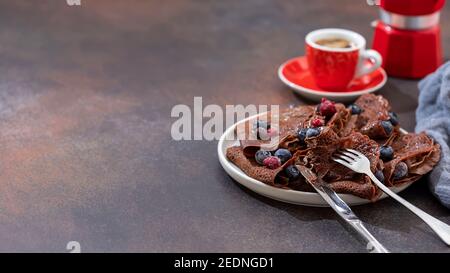 Crepes di cioccolato fatto in casa con frutti di bosco freschi e salsa al cioccolato. Messa a fuoco selettiva, spazio di copia Foto Stock