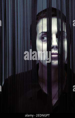 Donna capelli corti peering da dietro fringing Foto Stock