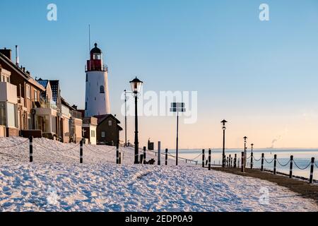 Inverno a Urk con la diga e la spiaggia presso il faro di Urk neve coperta durante l'inverno, tramonto dal faro di Urk Flevoland. Paesi Bassi Foto Stock