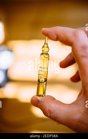 Contenitore in vetro per mano maschio POV con medicinale per vaccino all'interno Foto Stock