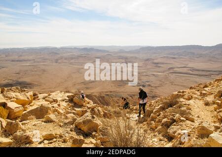 Un gruppo di escursionisti escursioni a piedi a Makhtesh Ramon una caratteristica geologica del deserto israeliano Negev. Situato sulla vetta del Monte Negev, il piu' grande 'ero' del mondo Foto Stock