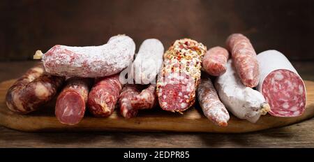 Vari tipi di salumi e salsicce su legno scheda Foto Stock