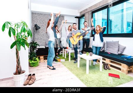 Giovani lavoratori dipendenti che hanno una pausa all'avvio Spazio di codorking - concetto di affari divertente di risorse umane che hanno rilassatevi sul posto di lavoro Foto Stock