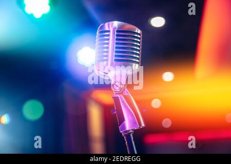Primo piano microfono retro vintage su sfondo multicolore sfocato. Foto Stock