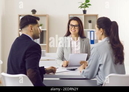 Amichevole manager di assicurazione o broker ipotecario incontro con i clienti a. il suo ufficio Foto Stock