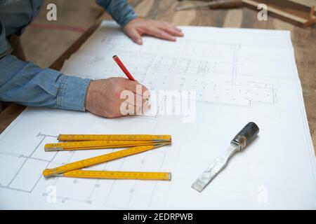 Architetto o artigiano disegna una pianta di costruzione o una casa piano Foto Stock