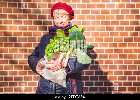 Foglie fresche Lattuga in sacchetto organico in mano donna, stile di vita sano Foto Stock