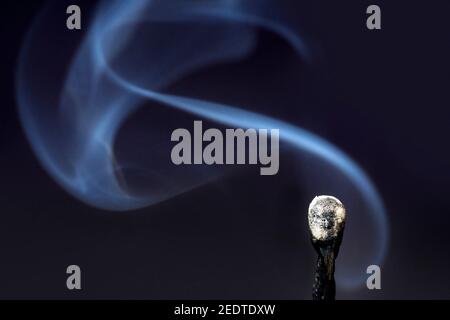 Fumo proveniente da una partita estinta su sfondo nero Foto Stock