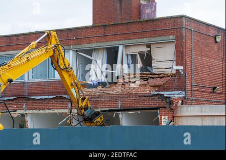 Demolizione di un vecchio edificio con una ganascia idraulica per macchine a lunga portata. Rigenerazione di uno spazio per un edificio nuovo e moderno. Foto Stock