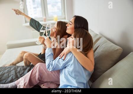 Allegri bicchieri da donna di vino frizzante godendosi l'un l'altro compagnia Foto Stock