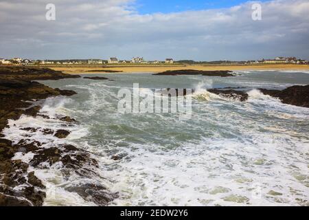 Vista sul lungomare e sulla spiaggia, sulle acque di mare dalle rocce. Trearddur Bay, Isola di Anglesey (Ynys Mon), Galles del Nord, Regno Unito, Gran Bretagna Foto Stock