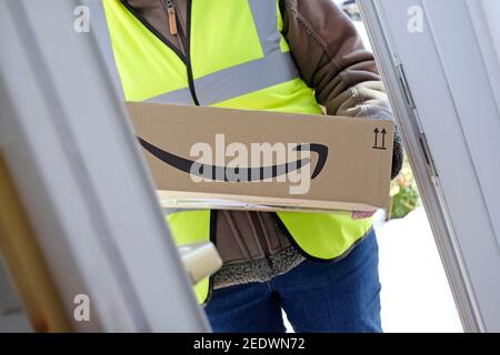 persona che consegna il pacco amazon alla porta d'ingresso, norfolk, inghilterra Foto Stock