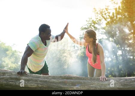 Allenatore di idoneità dà una certa motivazione alla donna che fa i push-up Foto Stock