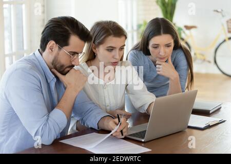 I giovani dipendenti caucasici si sono concentrati sulla soluzione del problema. Foto Stock