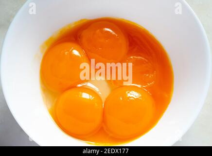Tuorlo d'uovo crudo in una ciotola bianca Foto Stock