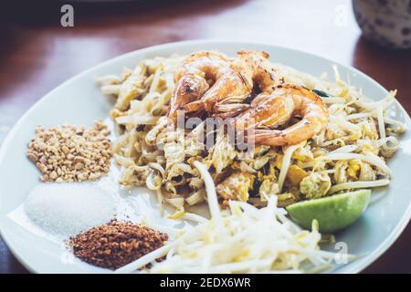 Pad thai fatto in casa con gamberi e verdure sul tavolo Foto Stock