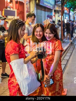 (210215) -- PECHINO, 15 febbraio 2021 (Xinhua) -- le ragazze che indossano il cheongsam, un abito da donna cinese tradizionale conosciuto anche come Qipao, scattano le foto a Chinatown a Bangkok, Thailandia, 11 febbraio 2021. L'anno 2021 è l'anno della Ox secondo lo zodiaco cinese. Con la cultura e il cibo cinesi sempre più popolari, la gente non solo in Cina, ma in tutto il mondo partecipa anche alle celebrazioni del Capodanno cinese. (Xinhua/Zhang Keren) Foto Stock