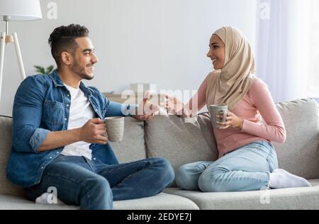 Coppia musulmana che beve tè e parla a casa Foto Stock