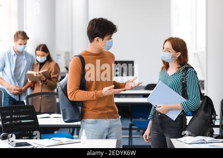 Studenti internazionali che indossano maschere mediche e parlano Foto Stock