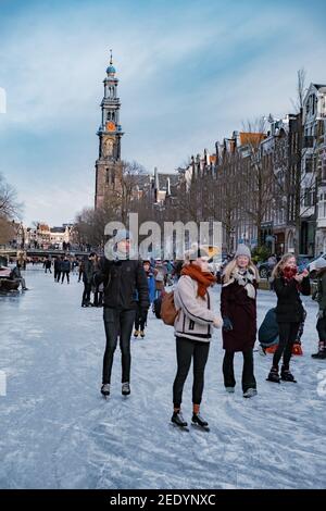 Amsterdam Olanda Febbraio 2021, pattinaggio su ghiaccio sui canali di Amsterdam Paesi Bassi in inverno, canali congelati ad Amsterdam in inverno. Foto Stock