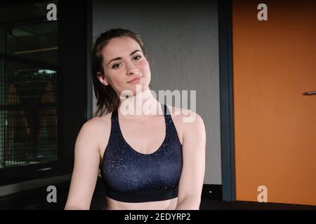 Bella giovane donna in palestra. La donna che si allenano in palestra pone per la macchina fotografica. Nella foto è presente un'area di scrittura. Foto Stock