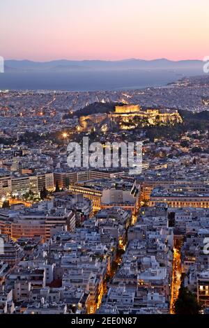 Vista della città di Atene, durante il tramonto. Sulla destra si può vedere l'Acropoli e il Partenone e sulla parte inferiore sinistra del parlamento greco. Foto Stock