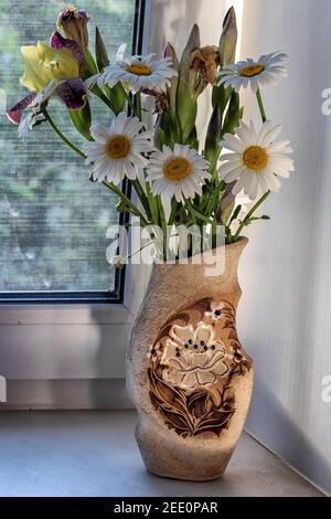 Un bel bouquet di fiori selvatici, margherite e taffè in un vaso. Foto Stock