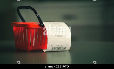 Ricevuta di acquisto nel cestino di shopping rosso. Spese di alimentari consumismo di mercato concetto Foto Stock