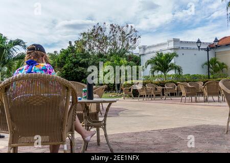 Cayo, Santa Clara, Cuba, febbraio 2016 - una donna caucasica rilassata su una sedia di rattan gode di una bevanda in una zona tranquilla del resort dell'hotel Foto Stock