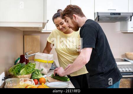 Misto-razza felice coppia preparando hummus vegan Foto Stock