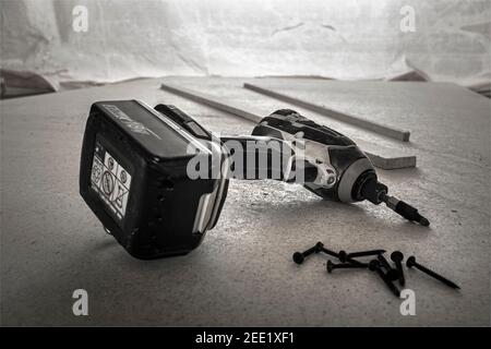 Avvitatore a percussione cordless e viti per cartongesso su scheda in gesso fibroso. Foto Stock