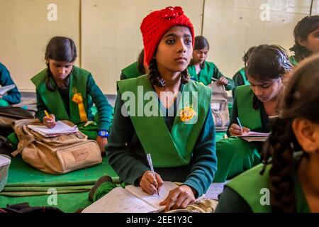 Utttar Pradesh. 05-15-2018. La ragazza prende appunti mentre frequenta una classe a scuola. Foto Stock