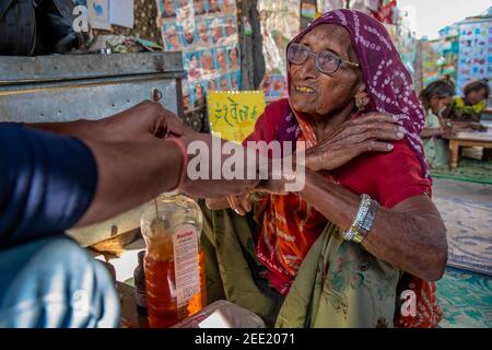 Rajasthan. India. 05-02-2018. La donna sta ricevendo assistenza sanitaria da un medico ambulanza che stava visitando la sua comunità. Foto Stock