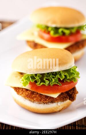 Mini Burger di pollo croccante con pomodoro alla lattuga e formaggio. Foto Stock